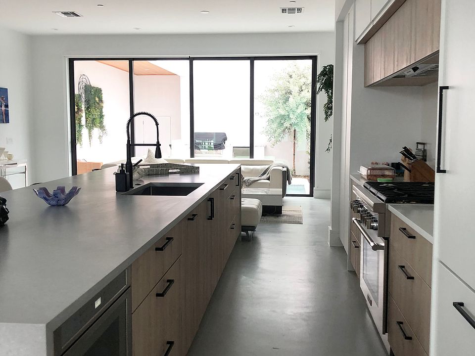 View of the kitchen from the dining room: the open-plan design creates an effortless flow for entertaining. It features an impressive 15-foot state-of-the-art kitchen island, Thermador appliances, and ample storage.