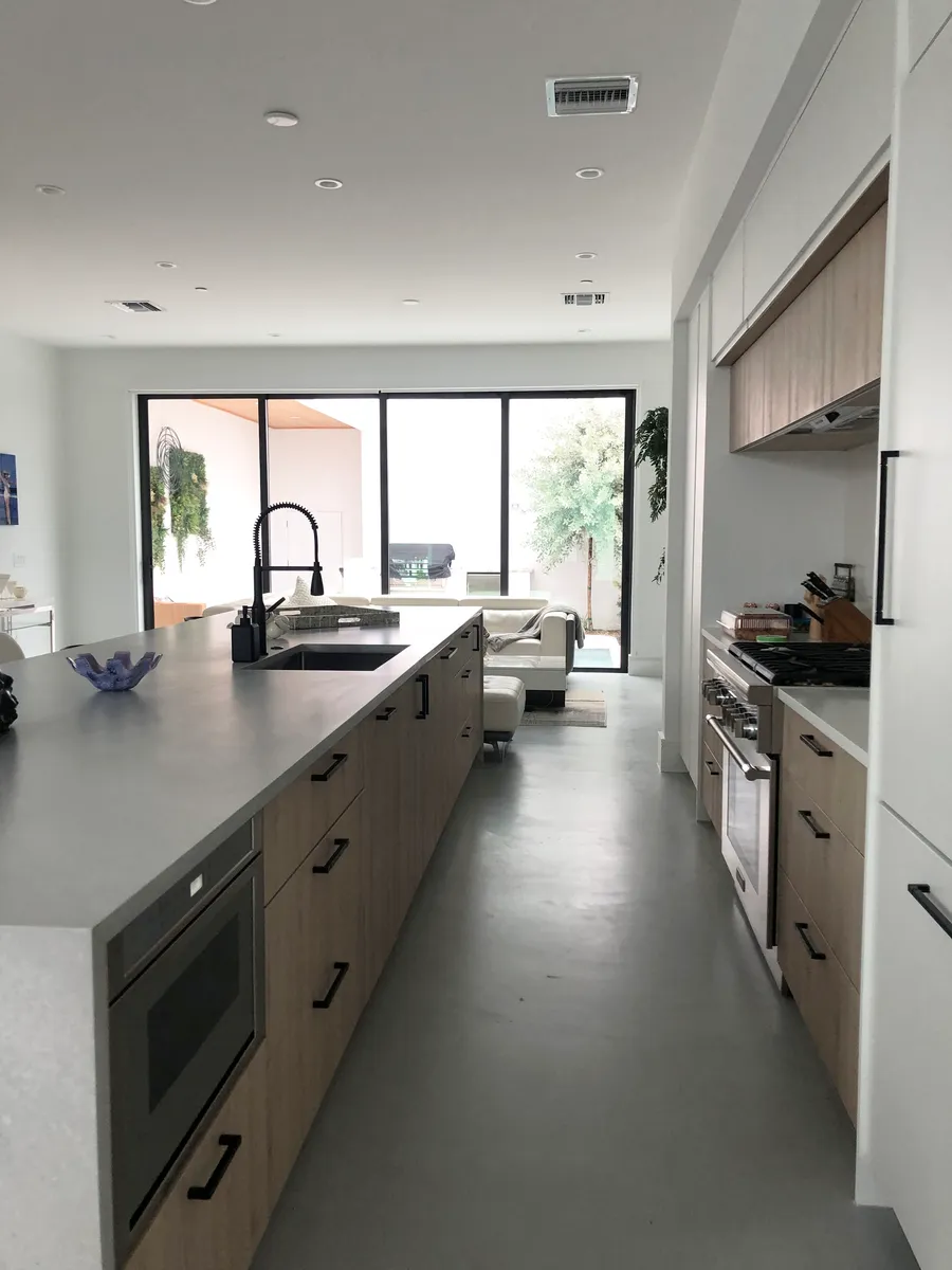 View of the kitchen from the dining room: the open-plan design creates an effortless flow for entertaining. It features an impressive 15-foot state-of-the-art kitchen island, Thermador appliances, and ample storage. - 1927 Dock St #1927