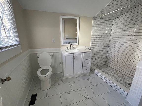 Newly tiled bathroom with walk-in shower.
