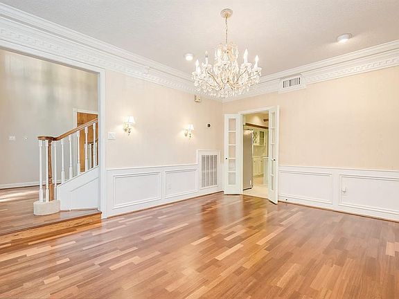 The formal dining room has laminate wood flooring and a beautiful chandelier.