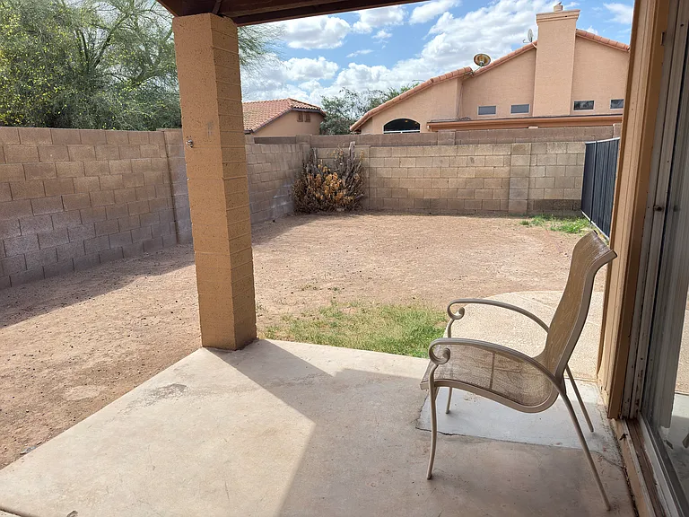 View of back yard from patio. Does not show new landscape and grass.
