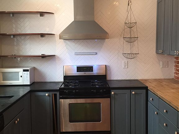 Custom kitchen with herringbone backsplash, soapstone a d butcher block counters, cherry hardwood flooring.