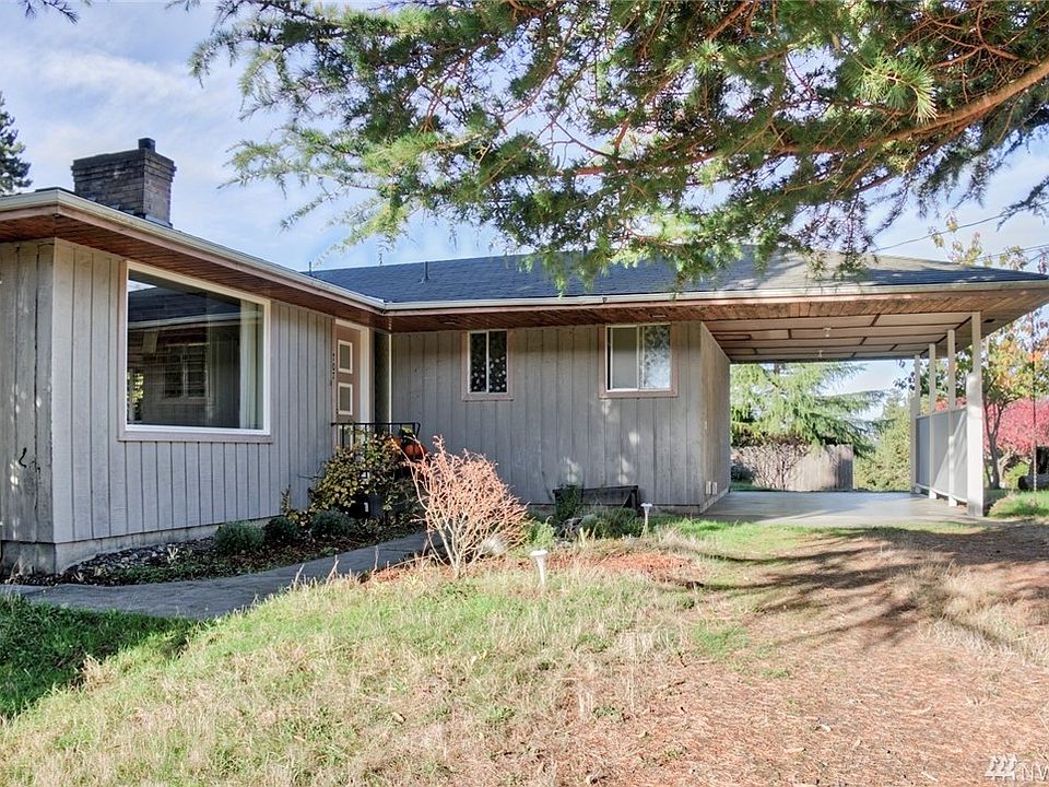 Entry on the main level. The carport can be accessed from both approaches and the huse sits on a corner lot.