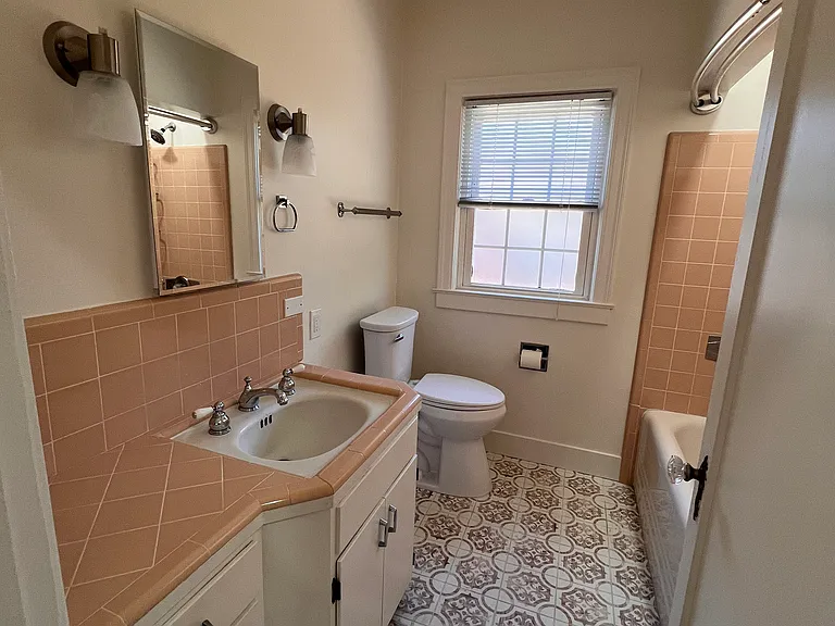 First bedroom with great natural light, ceiling fan, and closet with storage above.