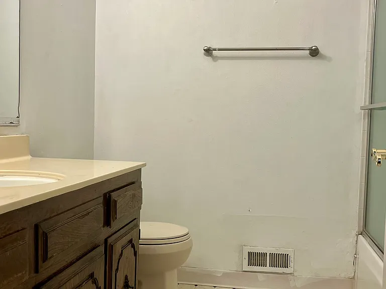 Hall bathroom includes ample counter space and an oversized mirror.