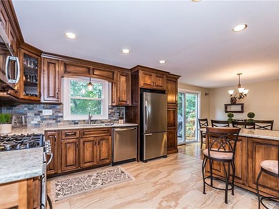 New kitchen with Amish built cabinets with toe kick storage, quartz counter tops, ceramic tile backsplash, and stainless steel a