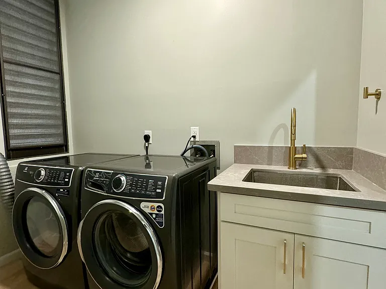 Downstairs laundry room/half bath with brand new Electrolux washer and dryer.