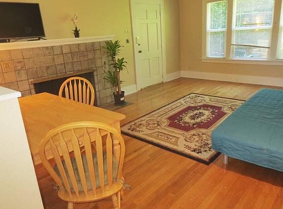 The living room also has a dining table and a fireplace.