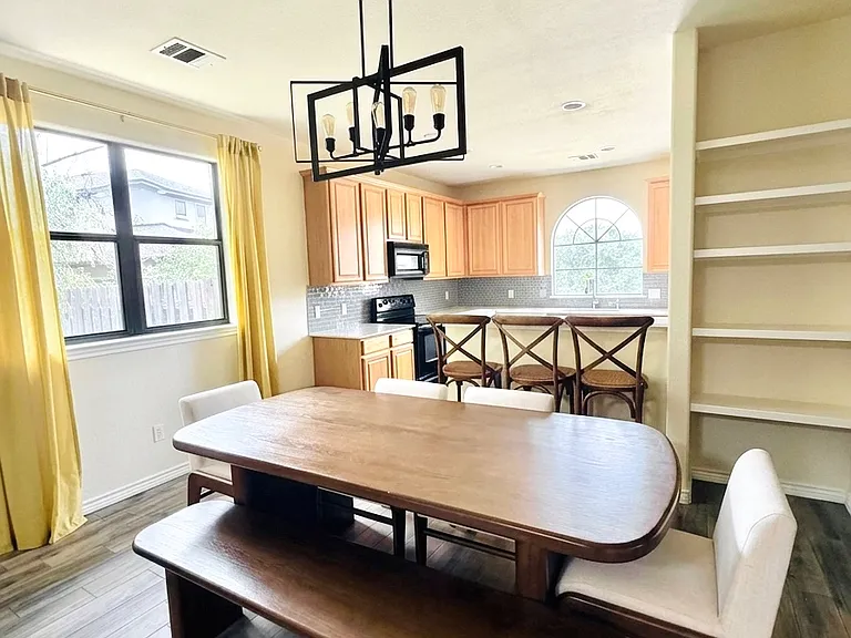 Open-concept dining area with modern lighting, built-in shelving, and breakfast bar-perfect for entertaining