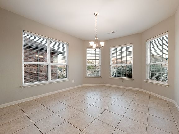 Unfurnished dining area with tile floors and a gorgeous chandelier.