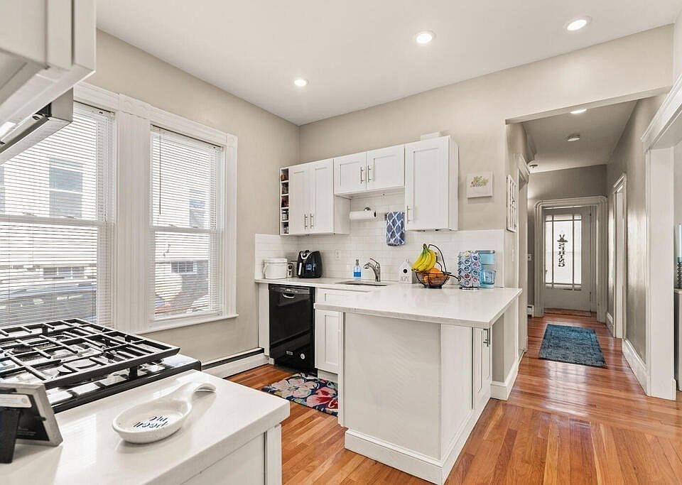 kitchen with quartz countertop, stainless steel appliances, hardwood floors, washing machine, dryer, and dishwasher