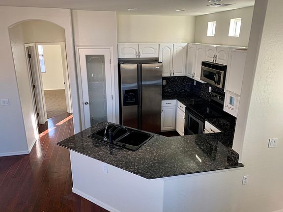 BRIGHT KITCHEN WITH GRANITE TOPS AND STAINLESS APPLIANCES