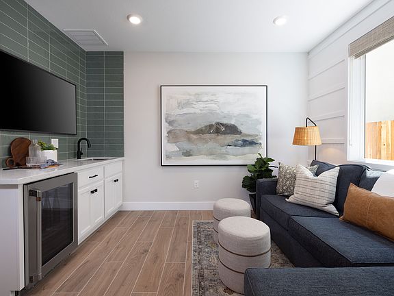 A modern and cozy living space with a kitchen area, a comfortable sofa, and a large abstract artwork