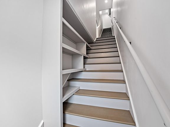 The entry stairwell includes custom shelving perfect for shoes, purses, and more!