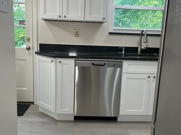 View into *brand new* kitchen from dining area. Side entrance at left.