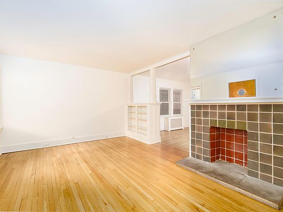Living room with dining room through the archway. Note the built-in bookcase to the right of the archway.