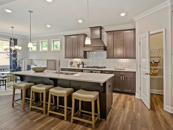 Kitchen, pantry and breakfast area layout. Example from Model Home. Actual rental home is unfurnished and flooring, counters, backsplash are shades of grey.