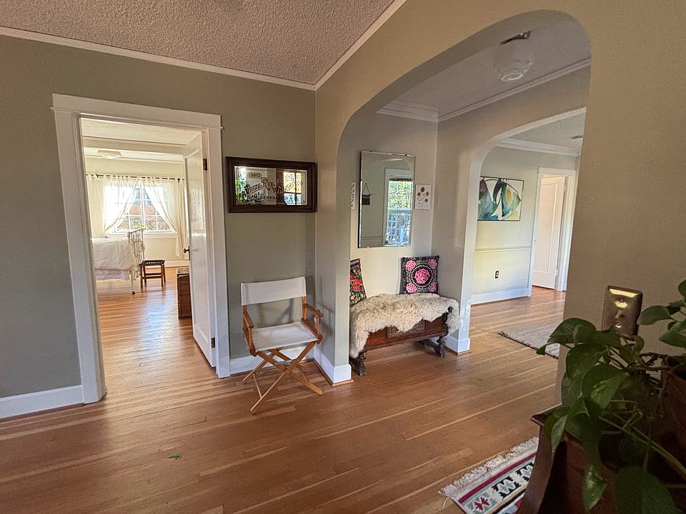 Classy curved archway between living room and entry hallway. View into bedroom and dining room