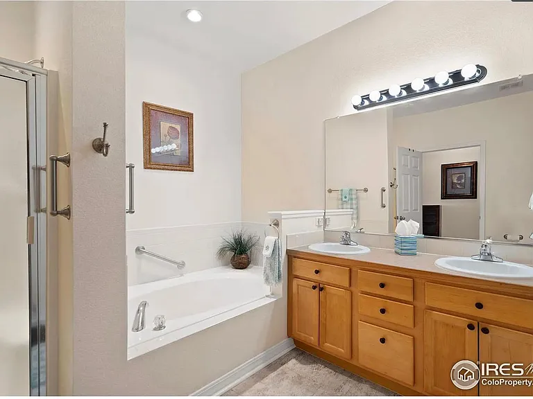 Primary suite bathroom with shower, large soaking tub, 2 sinks, toilet & access to walk-in closet