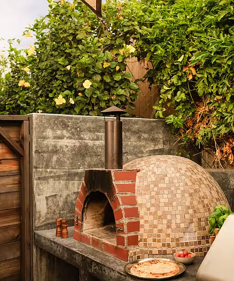 Spacious backyard packed with fun! Comfortable lounges, gather around the fire pit, cook on the pizza oven or BBQ, play the giant chess set, enjoy the playground, or watch movies on the large projector screen. Endless ways to play and unwind.