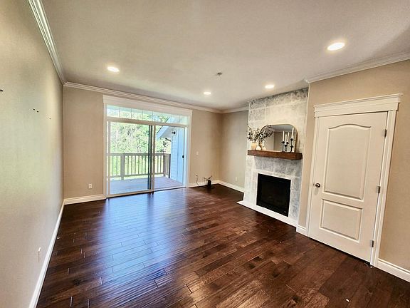 Living room with nook, gas fireplace, coat closet. Patio access with additional storage.