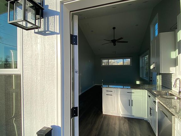 A private entrance with a keyless lock opens up into a warm, modern apartment with large windows and streaming sunlight.