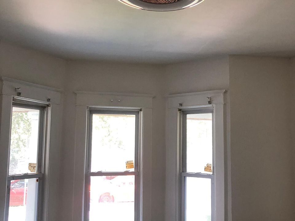 Living room with bay windows and contemporary ceiling fan/light combo