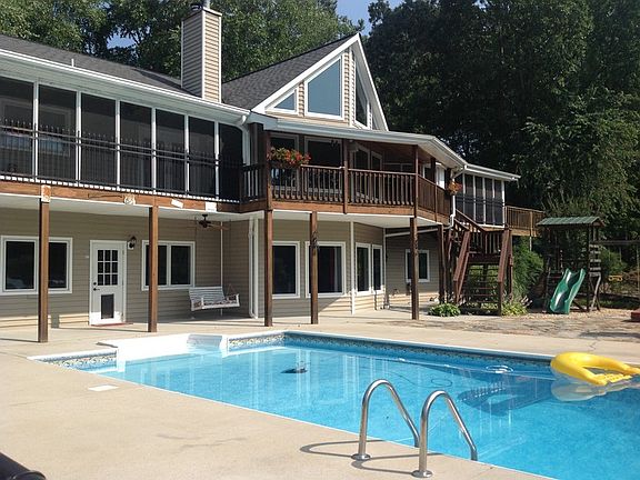 Back View with Saltwater Pool
						:
						Fireplace, in-ground hot tub, and play area.