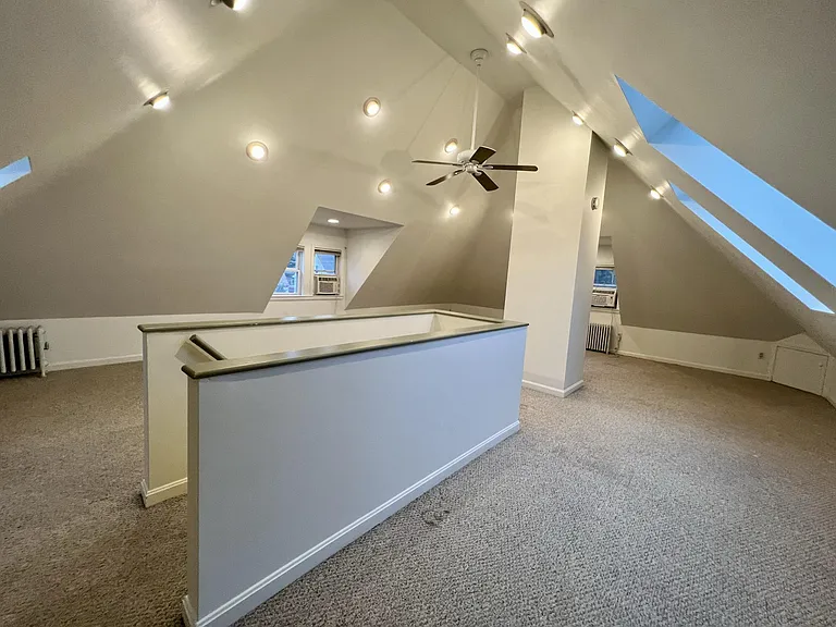 Top floor living room/mixed use space with skylights and LED lighting