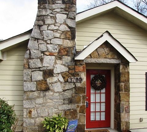 The front door is flanked by a real masonry granite chimney