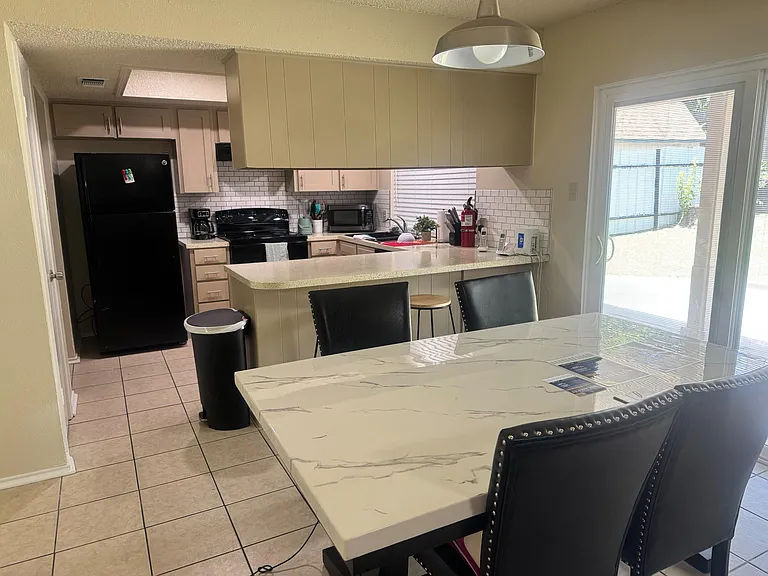 Kitchen with breakfast bar seating, full-size appliances, ample cabinetry, and easy access to the adjacent dining area.