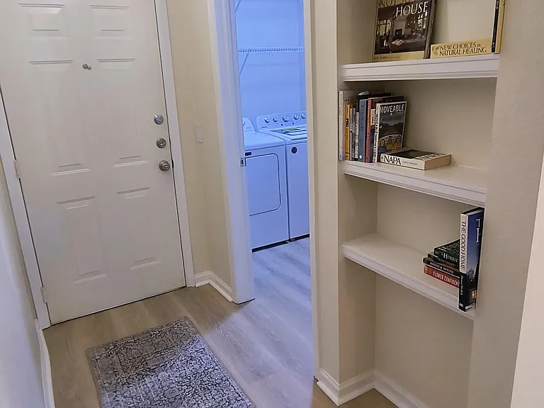 Entry hall with built-in shelving and access to spacious laundry room with new Maytag washer and dryer.