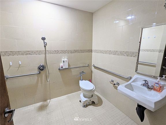 Roll-In bathroom, wall handles, and wall mounted sink for easy access.