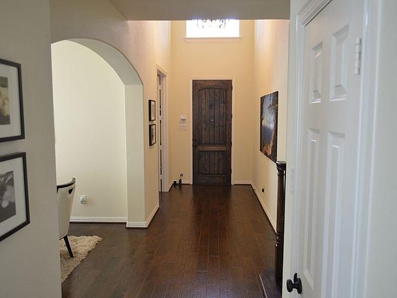 Entrance with wood flooring, high ceilings, and an 8 foot wood door to add drama to the entry.