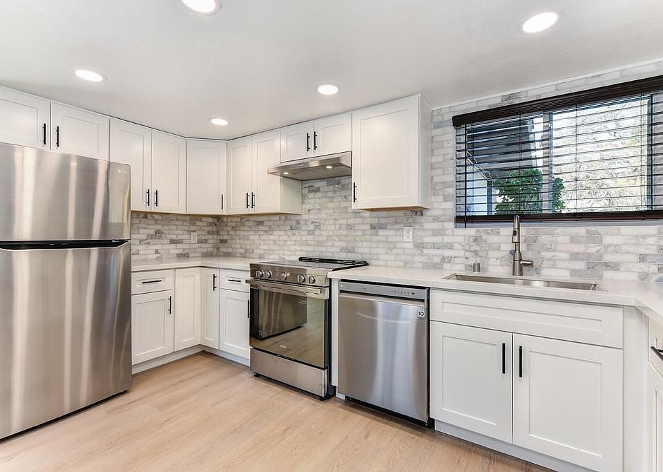 Kitchen area featuring high end convection slide in oven, Z-line range hood, LG dishwasher, deep stainless steel sink, LG fridge