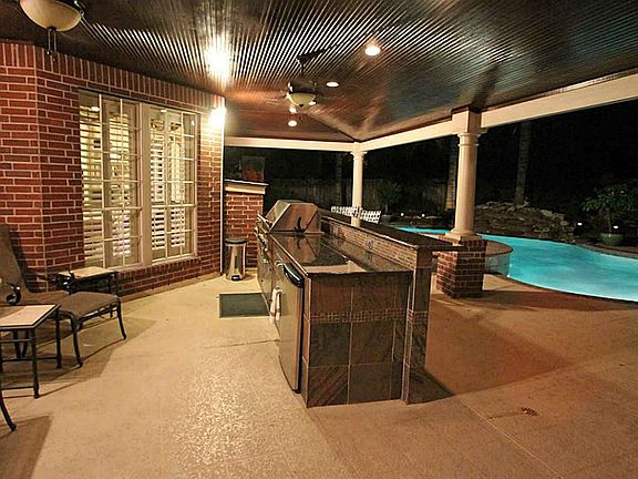 This outdoor entertainment area is first class with recessed lighting, fans, wood paneled ceiling, g