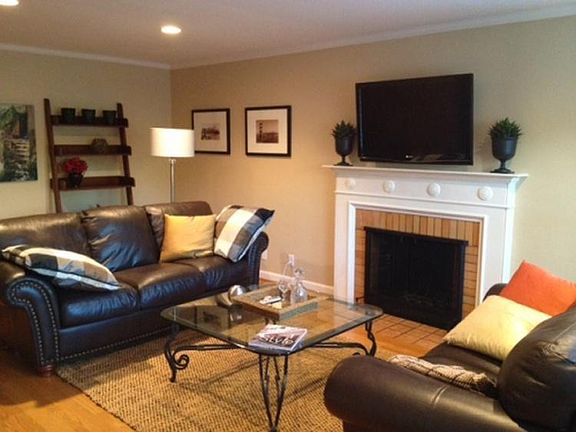 Livingroom with newly refinished hardwood floors, wood fireplace and 2 large picture windows.