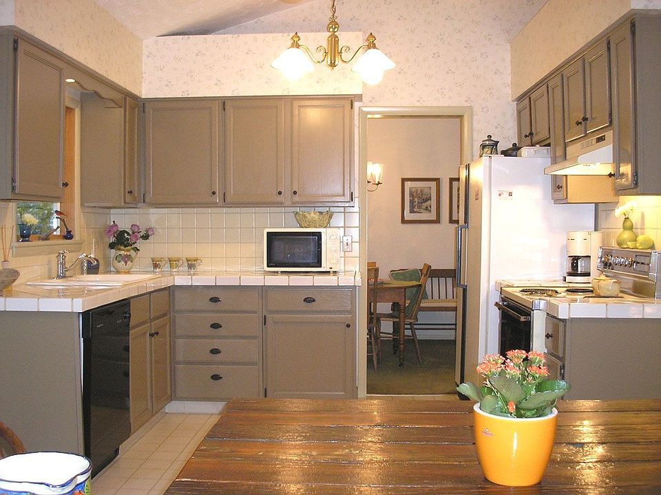 Vaulted kitchen with custom ceramic tile counters and sliding doors to back