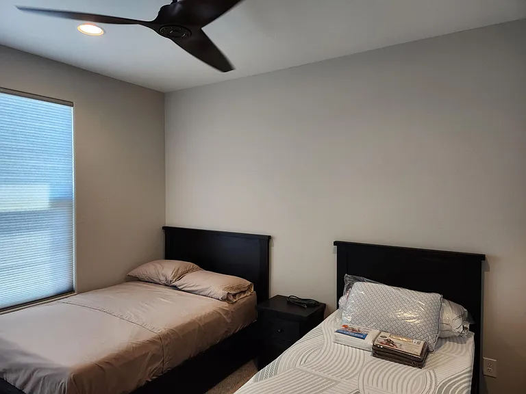 Guest bedroom with full and twin beds and ceiling fan