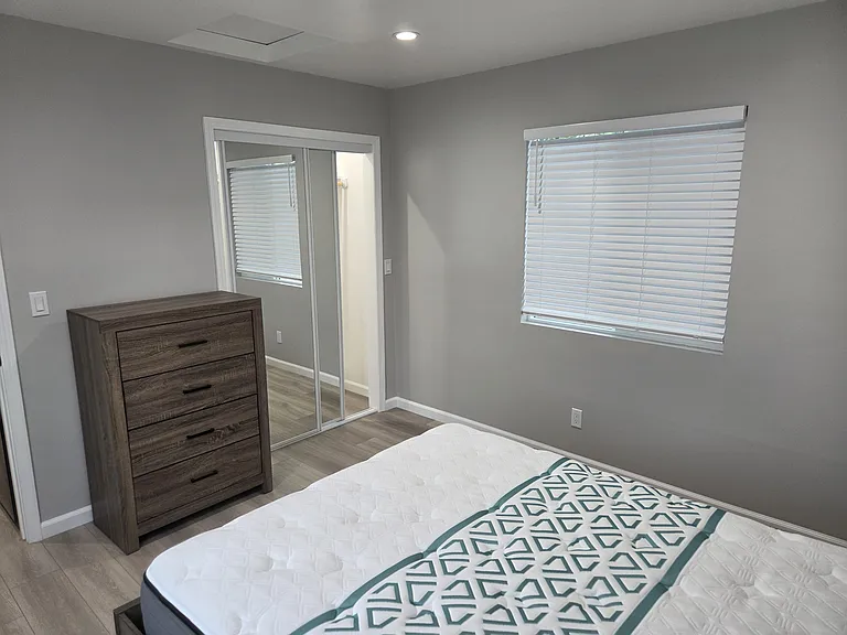 Bedroom with mirrored closet doors and light. Remote a/c unit. Two large windows.Queen size bed
Dresser and nightstand