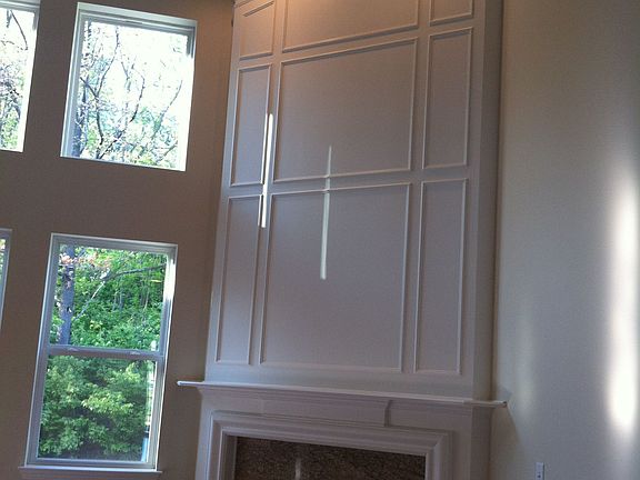 Living room with gas fireplace and floor to ceiling windows. 