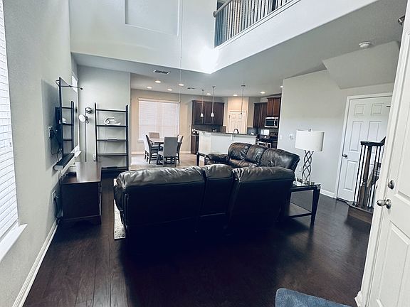 Main entry with grand two-story entrance over living area and open floor plan, attached to kitchen and dining for easy entertainment