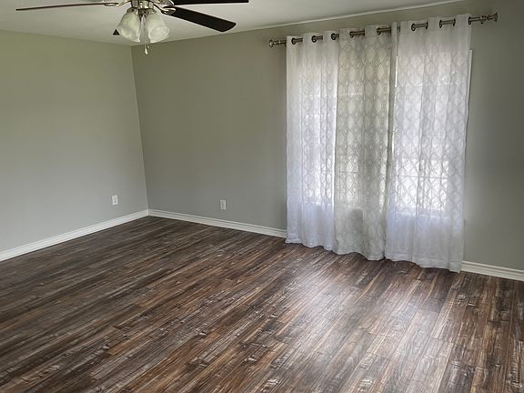 Living room, rustic floors and stainless ceiling fan.