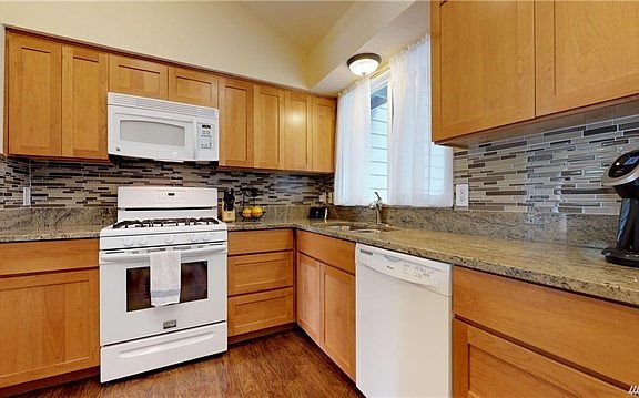 Updated Kitchen with Granite Counters and Brick Laid Tile Backsplash
