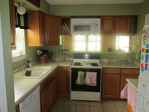 KITCHEN WITH BUILT IN MICROWAVE, ELECTRIC RANGE,OAK CABINETS AND BAR