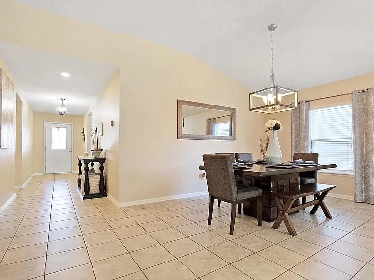 Hallway lead to living room with open kitchen and dining space.