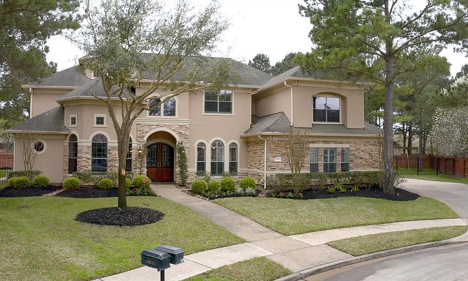 Elegant Mediterranean Style Home By Partners in Building. Stucco and Stack Stone with Arched Windows and Beautiful Stone Detail.