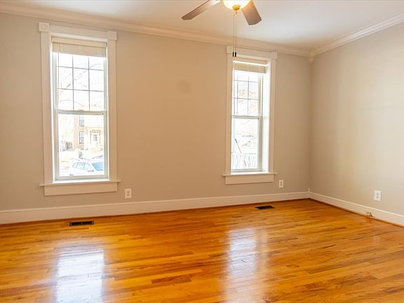 Front living area features high ceilings, oversized windows, hardwood oak flooring and crown molding