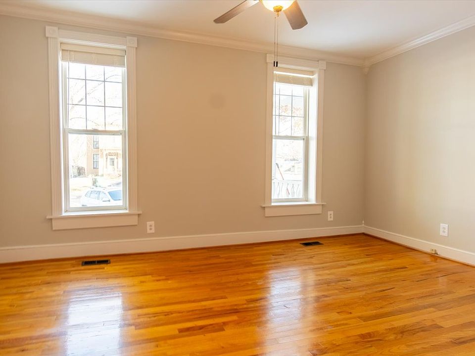 Front living area features high ceilings, oversized windows, hardwood oak flooring and crown molding