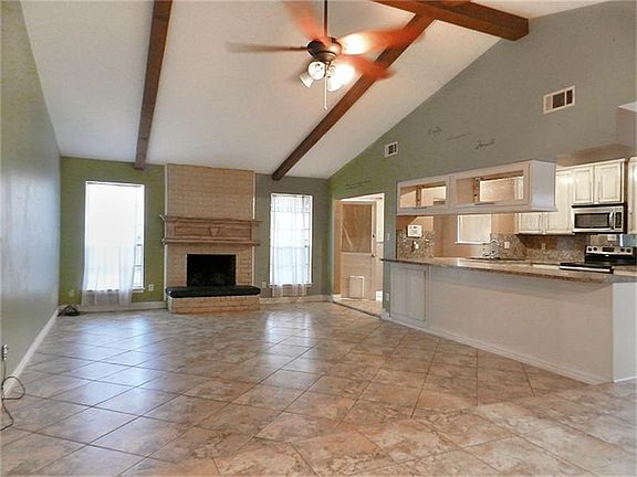 Living room with high ceiling and fireplace.